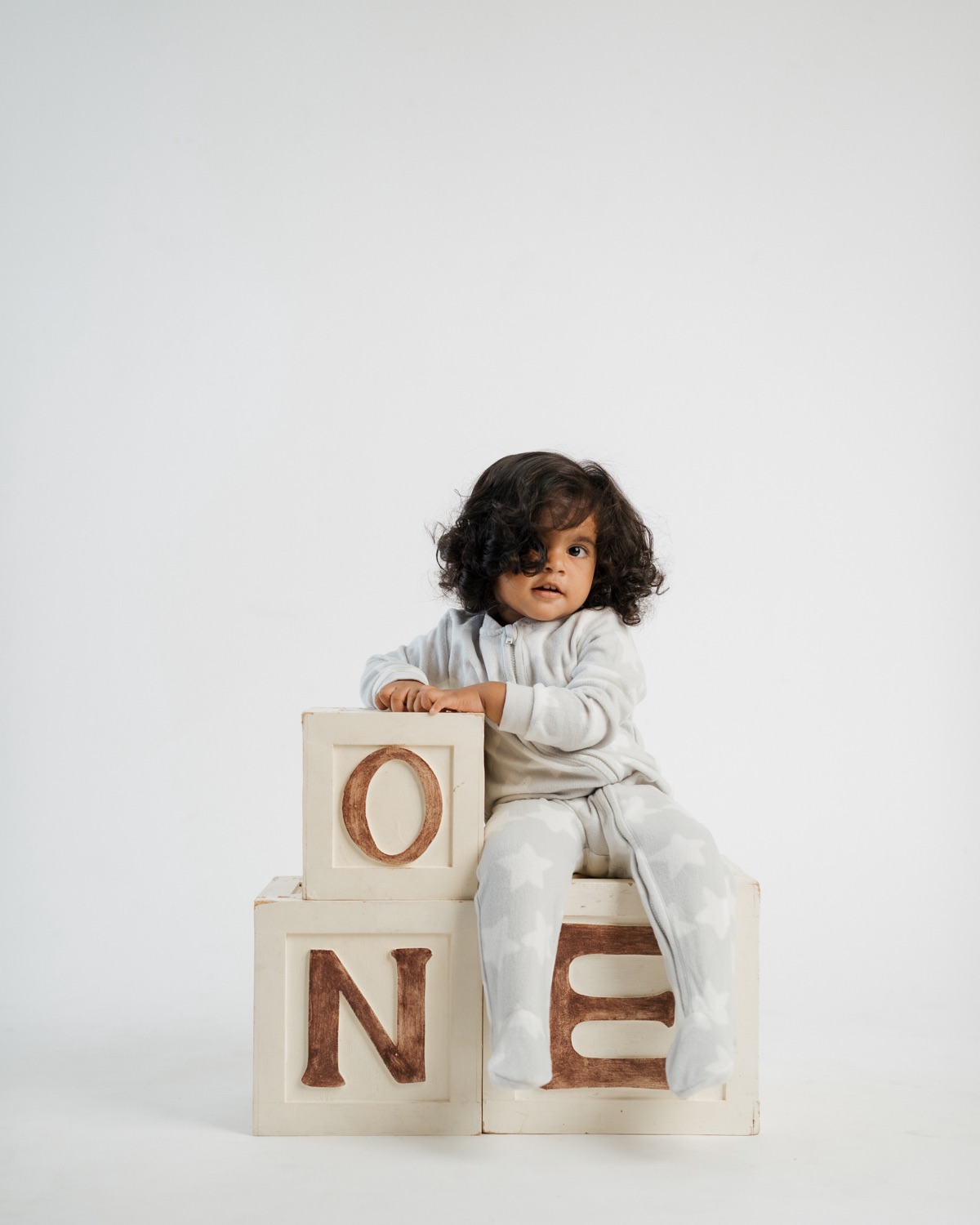 One year old with lettered blocks in studio