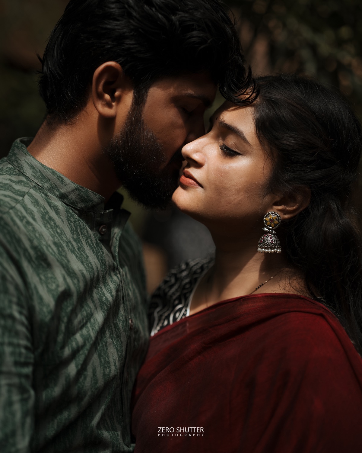 Couple close together in traditional dress, softly lit