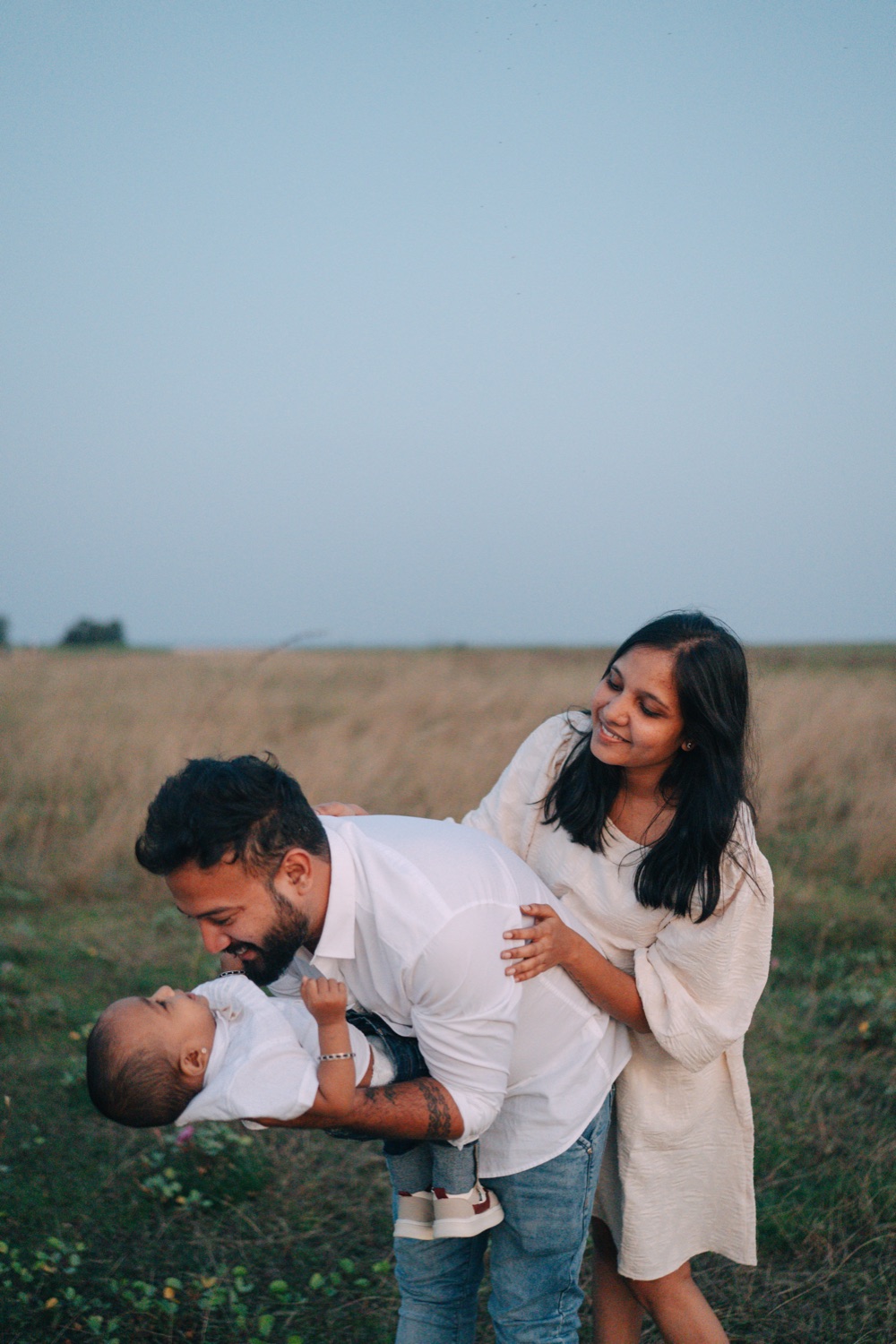Father lifting his baby for a nose-to-nose moment at golden hour