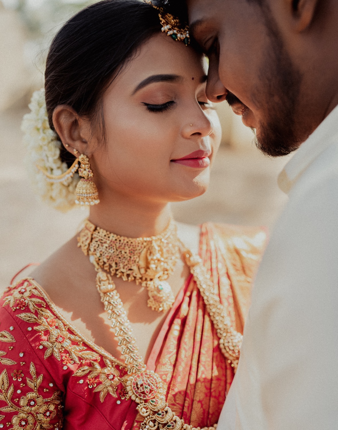 Bride and groom forehead to forehead, jasmine in her hair